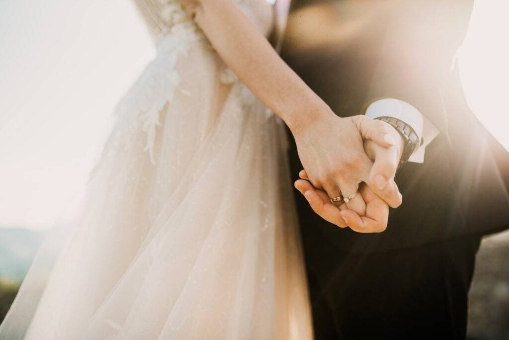 A US citizen newly married holds hands with their partner
