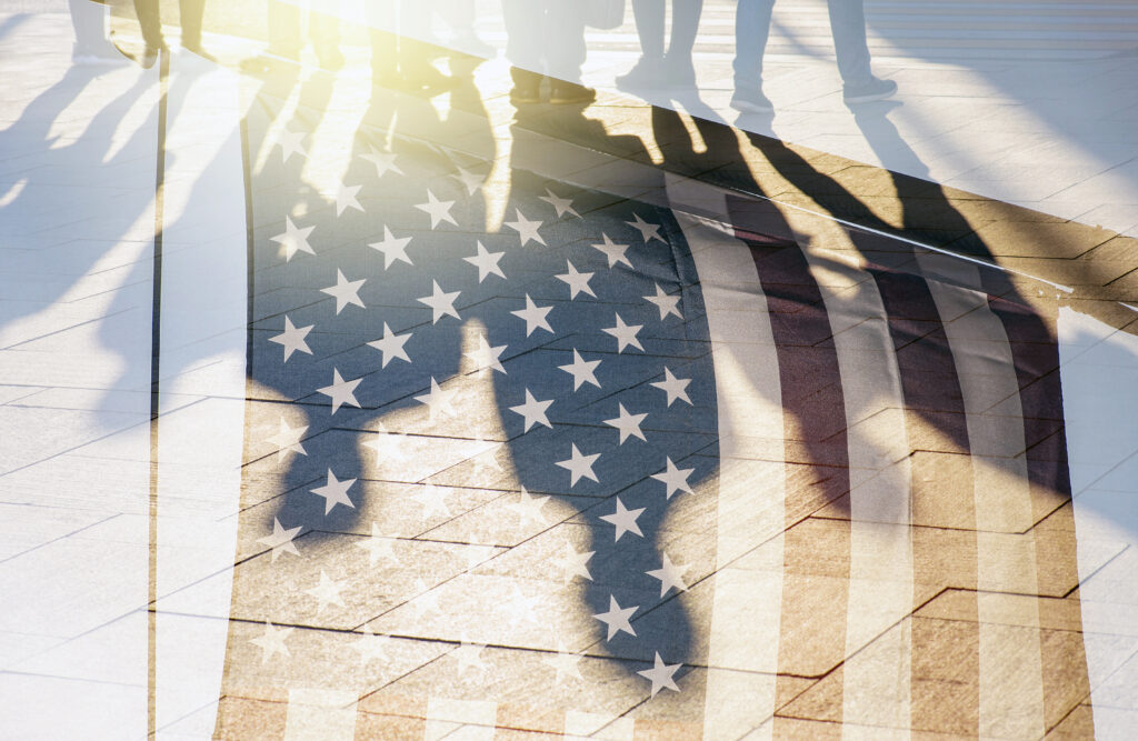 Shadows of People in a street and Flag of The USA as Background concept toned Picture