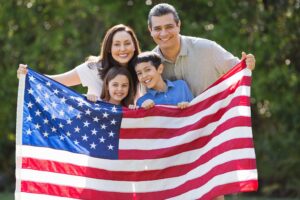 a family holding an American flag after receiving green cards