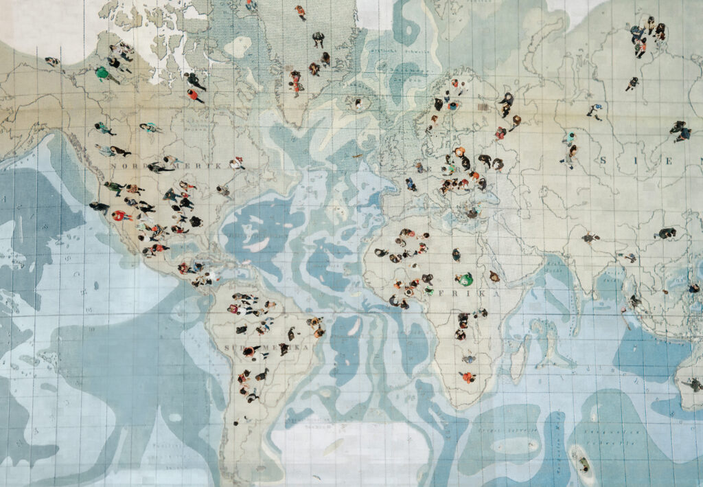 people standing on a large map, arial view, immigration theme
