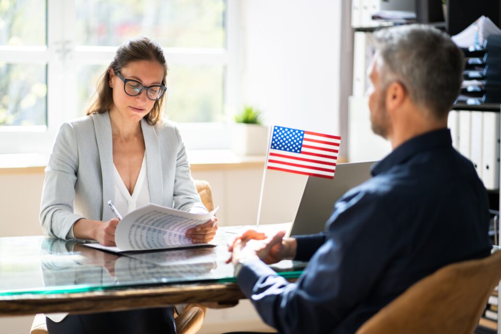 An EB-1A visa lawyer discusses immigration options with a client in her office.